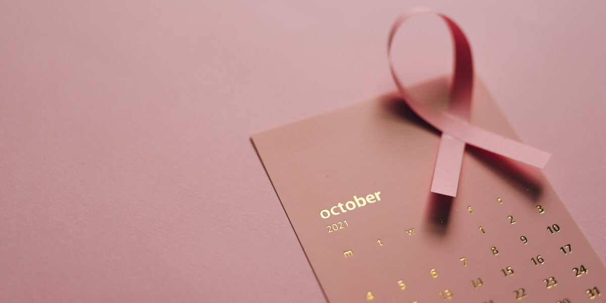 Photo d'un calendrier du mois d'octobre accompagné d'un ruban sur fond rose
